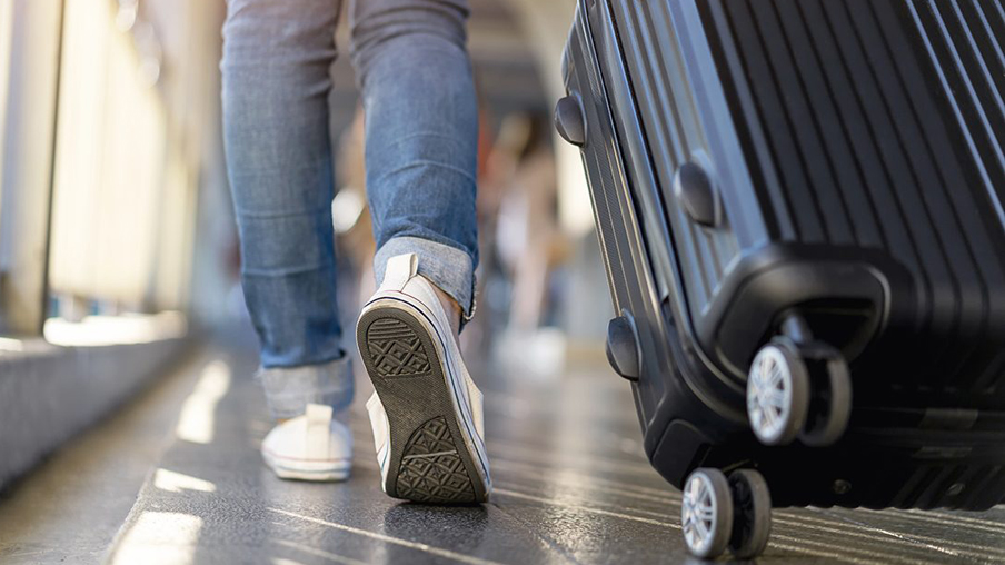 Mujer camina en el aeropuerto con su maleta